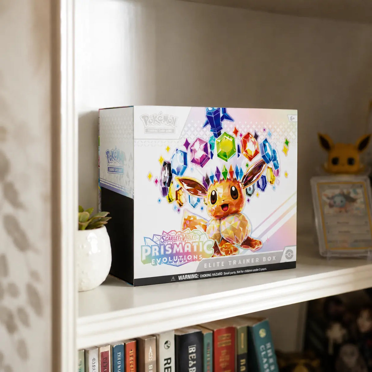 Pokemon Prismatic Evolutions Elite Trainer Box im Regal – Lifestyle mit Eevee Funko Pop und gegradetem Vaporeon